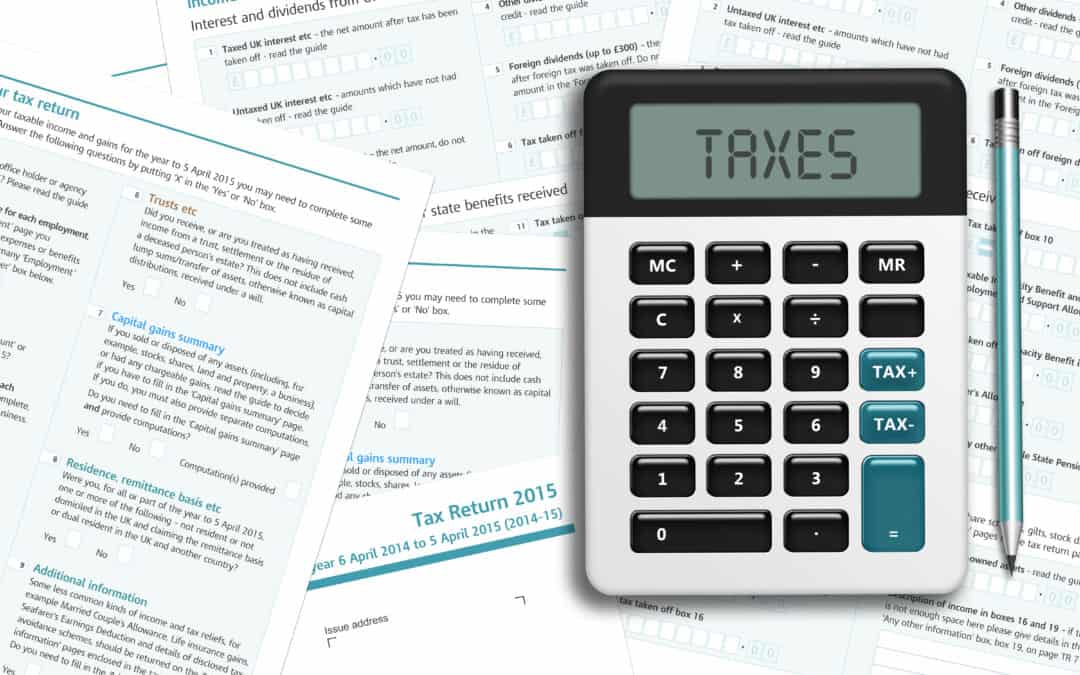 UK tax form with calculator lying on wooden desk as businesses consider business rates in preparation of the upcoming Autumn budge